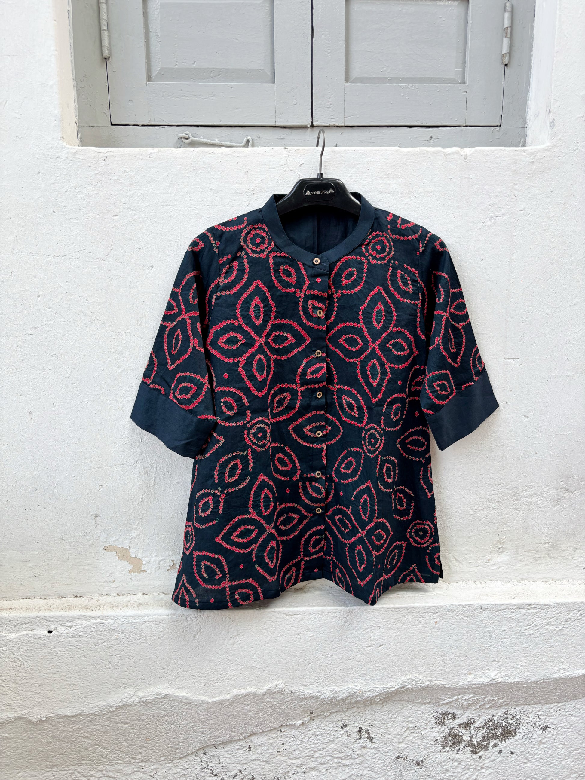 Midnight navy blue Jhankar Bandhani cotton shirt with raspberry rose floral motifs, soft mandarin collar, folded sleeve cuffs, coconut shell buttons and relaxed fit.