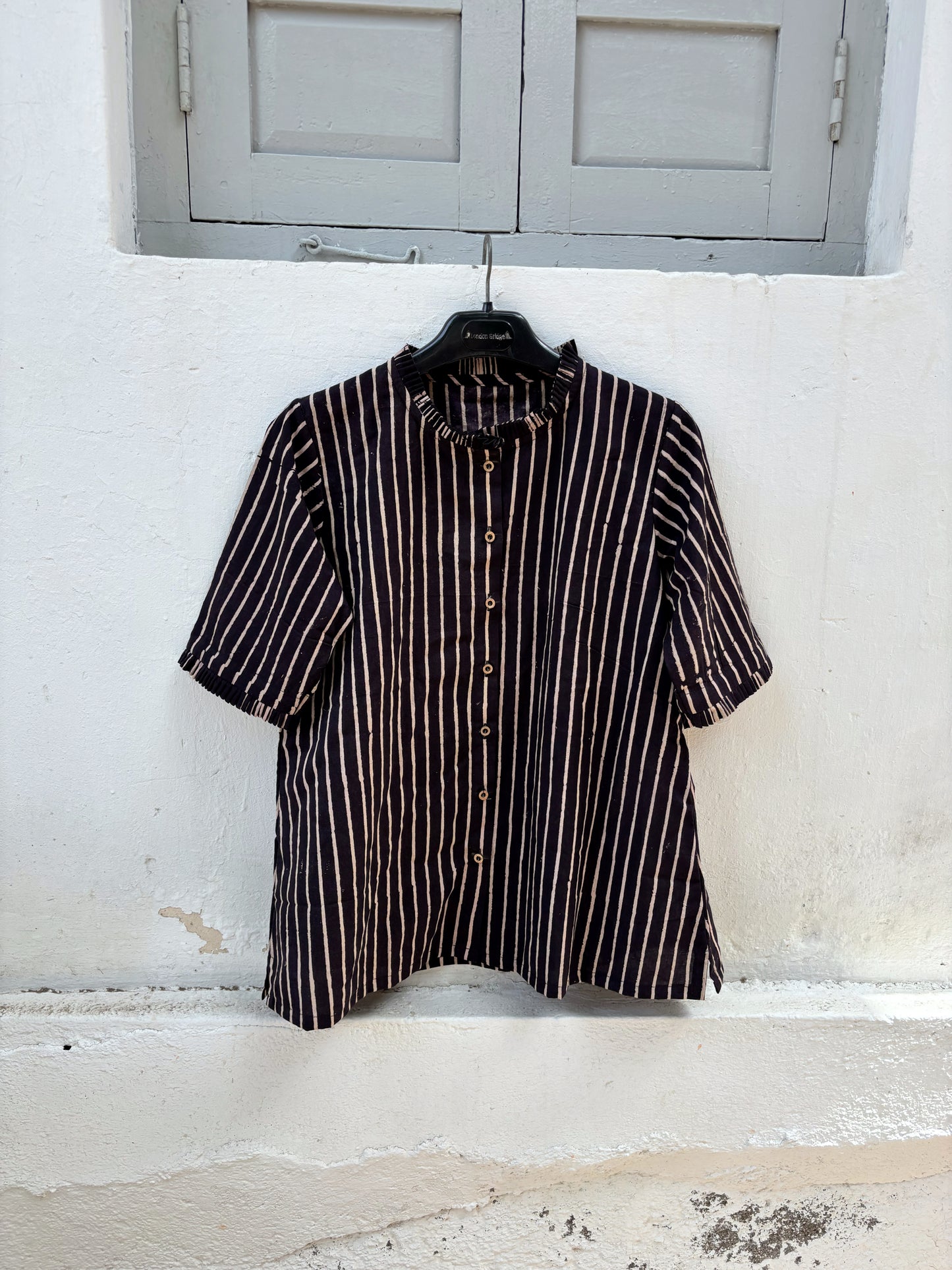 Ajrakh hand block printed cotton shirt with natural dyed beige stripes on a deep midnight base, pleated neckline, pleated sleeve hems and relaxed fit.
