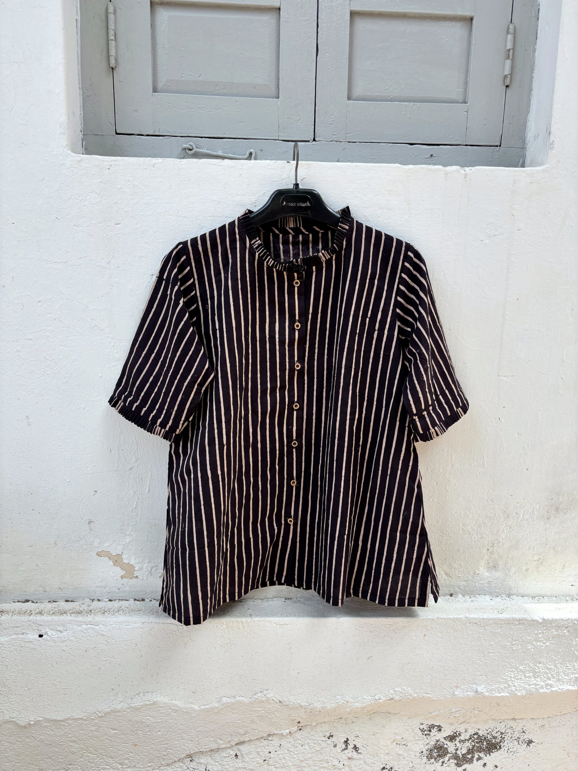 Ajrakh hand block printed cotton shirt with natural dyed beige stripes on a deep midnight base, pleated neckline, pleated sleeve hems and relaxed fit.

