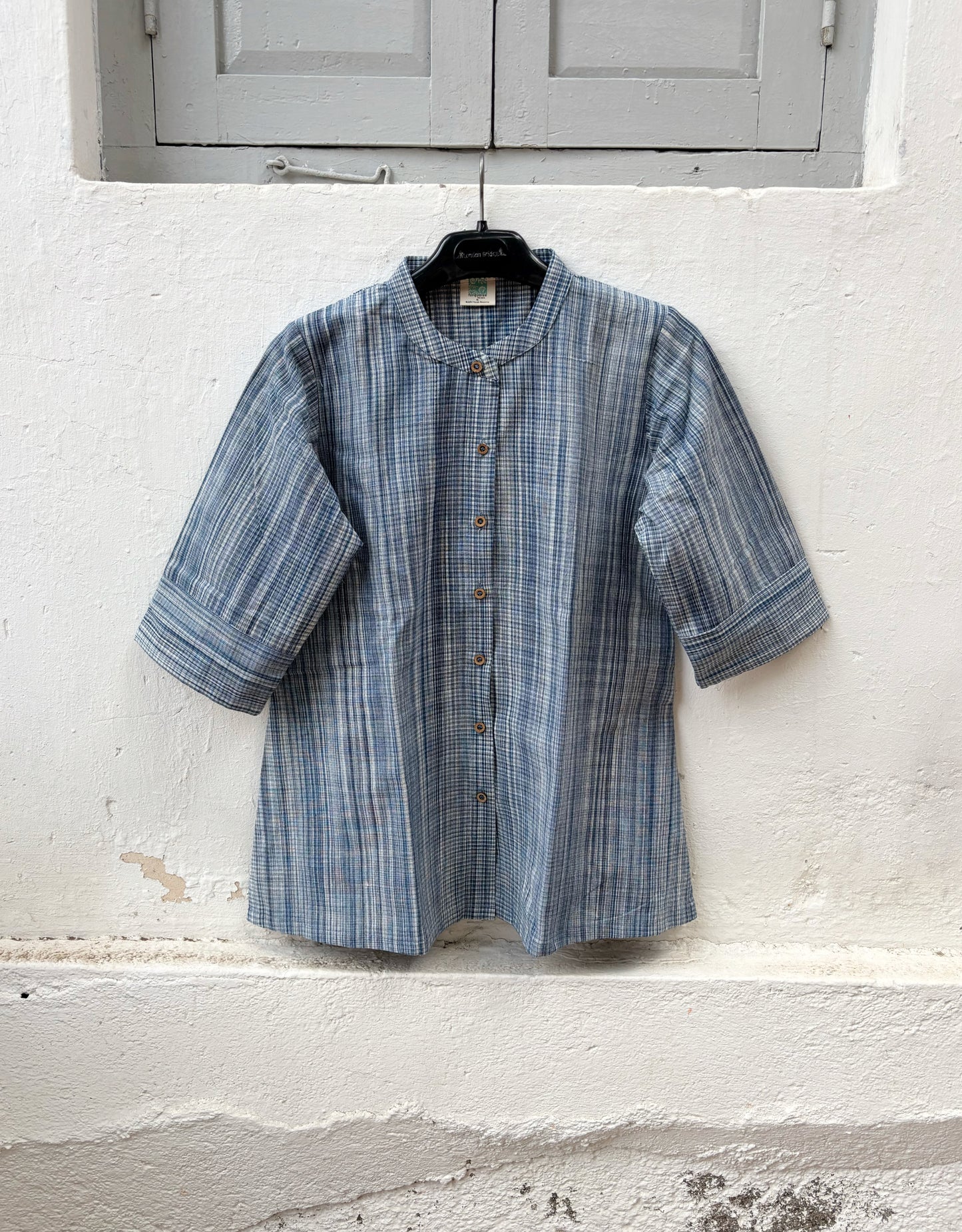 Hand spun handwoven cotton striped shirt in mist blue and ivory. Slow-made with a soft mandarin collar, relaxed fit and breathable woven texture.
