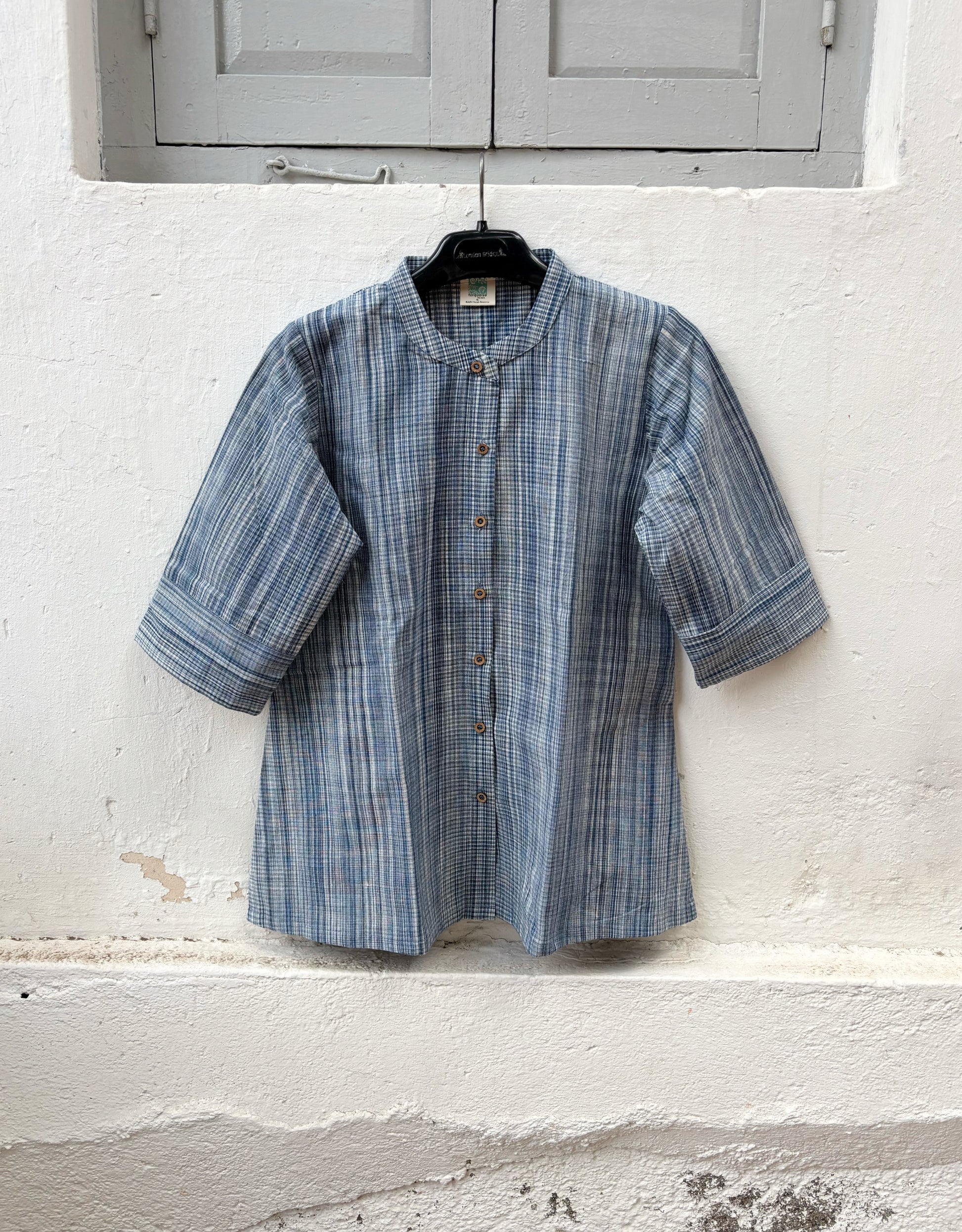 Hand spun handwoven cotton striped shirt in mist blue and ivory. Slow-made with a soft mandarin collar, relaxed fit and breathable woven texture.
