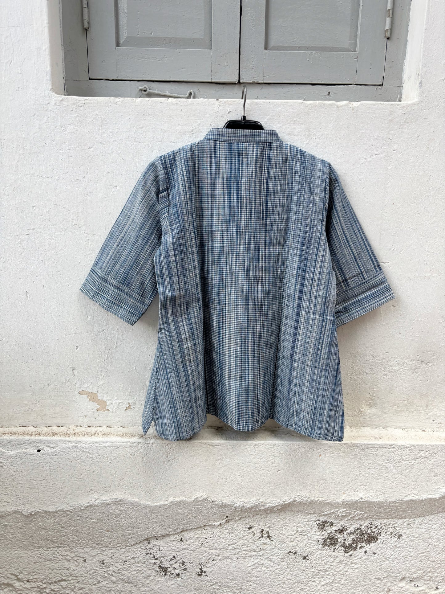 Hand spun handwoven cotton striped shirt in mist blue and ivory. Slow-made with a soft mandarin collar, relaxed fit and breathable woven texture.
