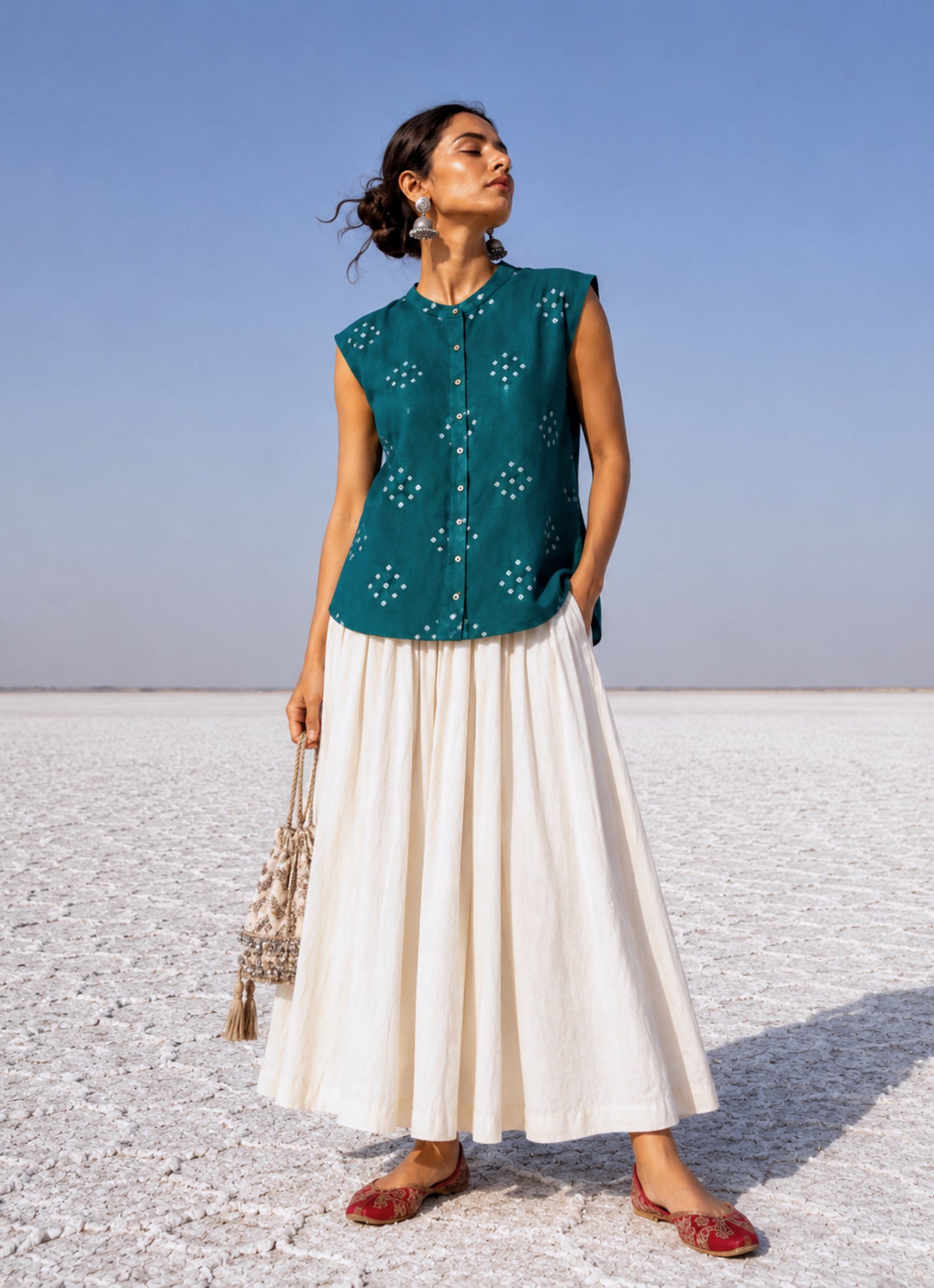 Handspun handwoven organic cotton sleeveless Bandhani shirt in peacock teal green with soft mandarin collar and relaxed fit.