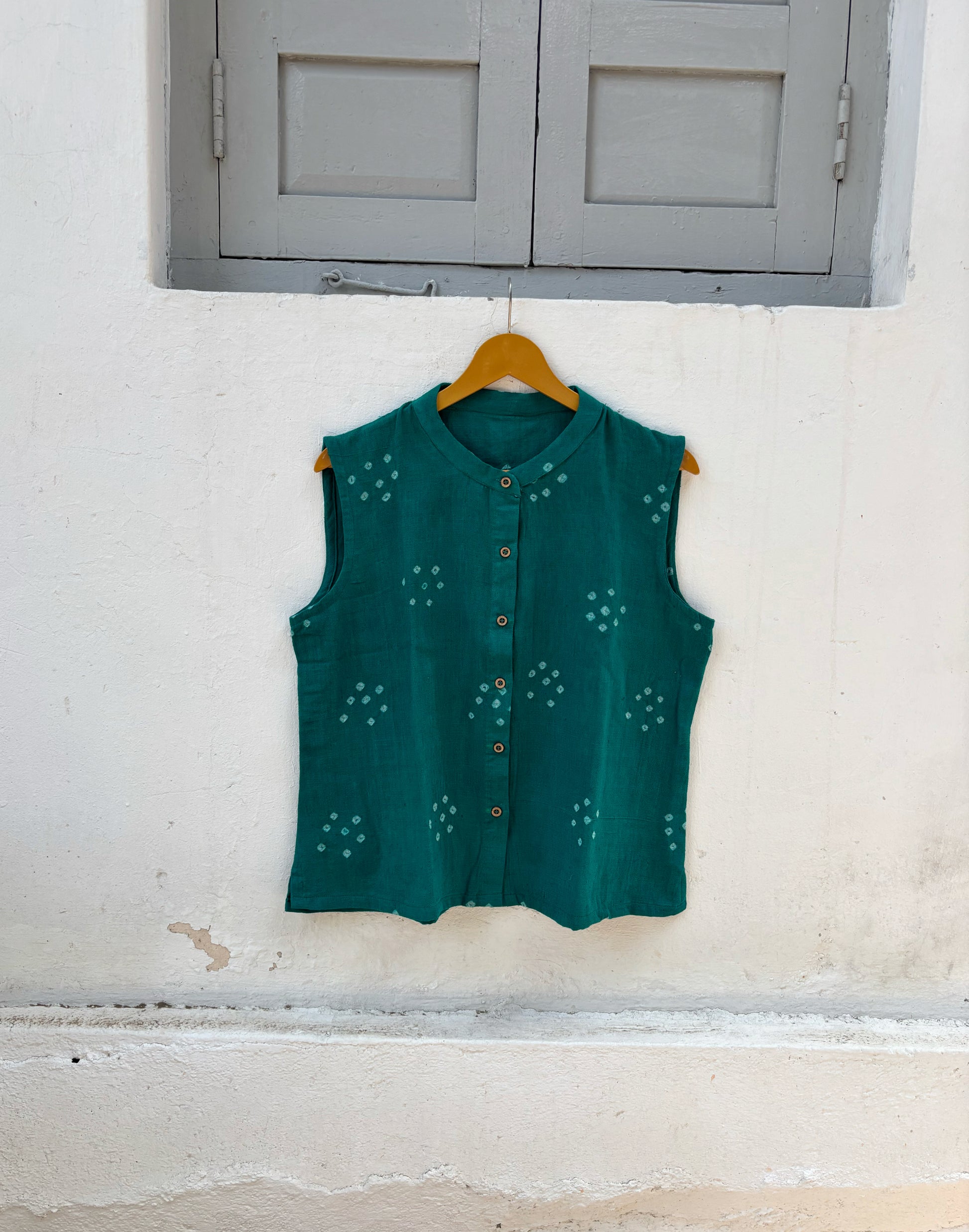 Handspun handwoven organic cotton sleeveless Bandhani shirt in peacock teal green with soft mandarin collar and relaxed fit.