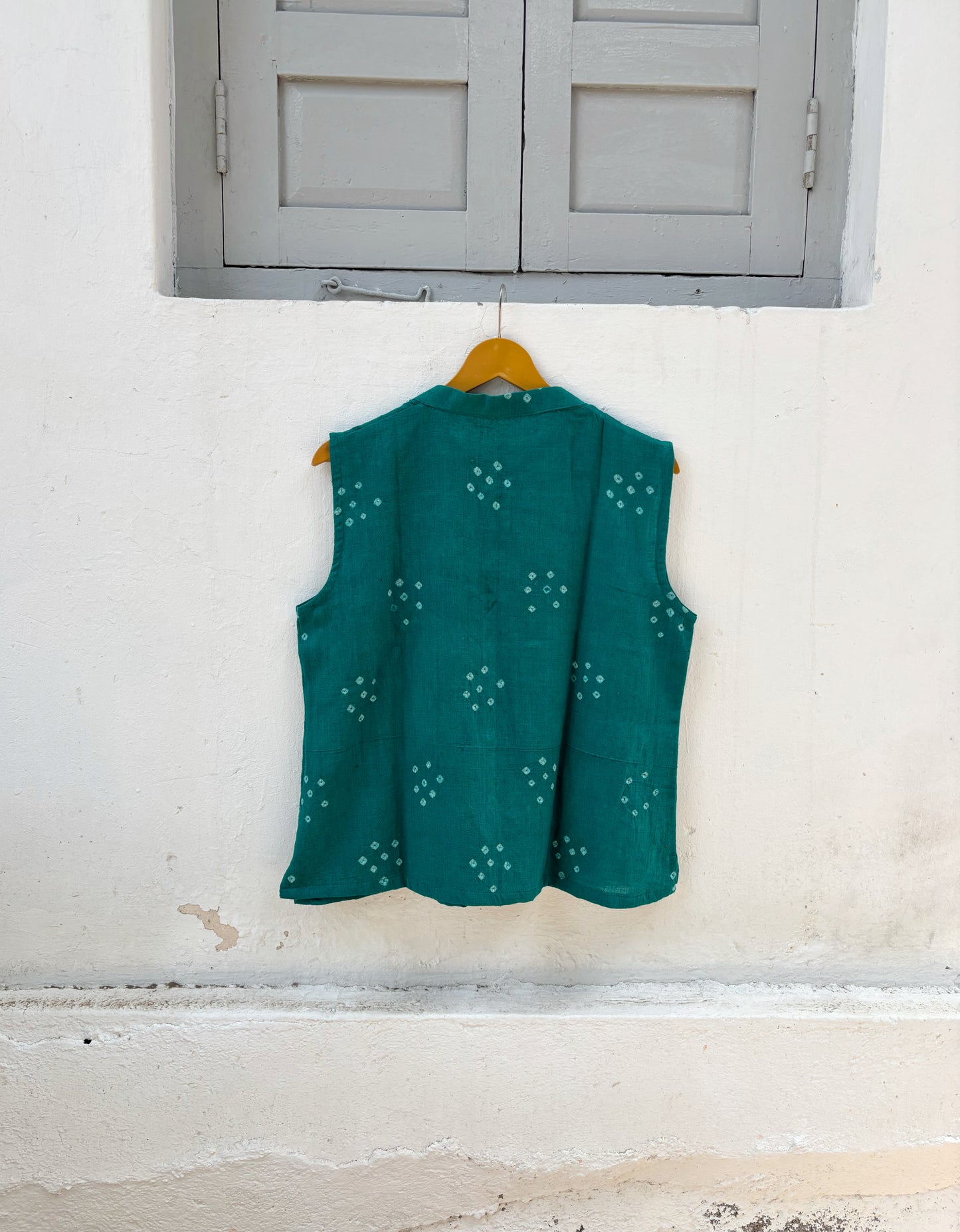 Handspun handwoven organic cotton sleeveless Bandhani shirt in peacock teal green with soft mandarin collar and relaxed fit.