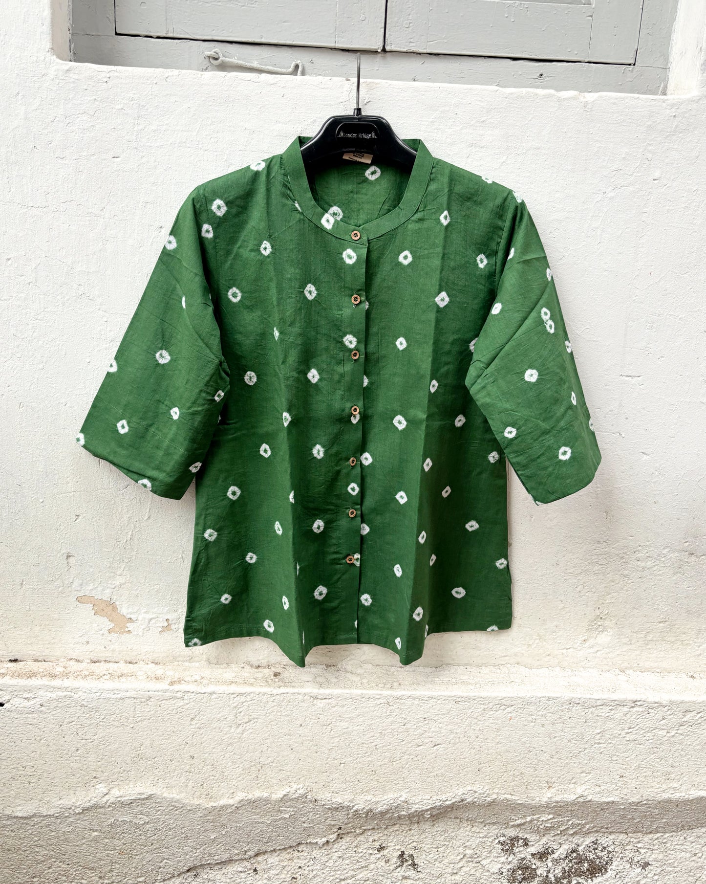 Relaxed fit moss green Bandhani cotton shirt with wooden buttons.