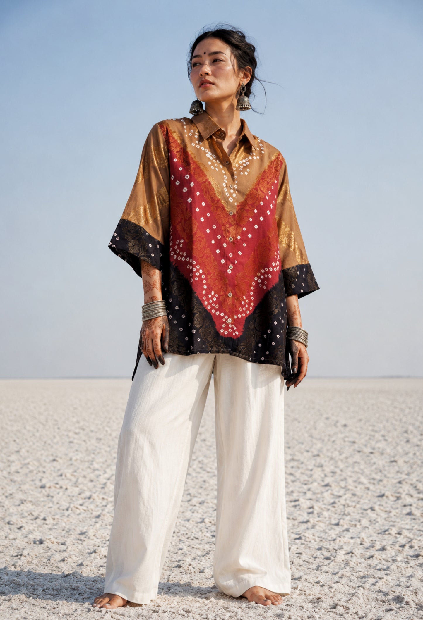 Handcrafted Bandhani festive cotton shirt in Earth Brown, Rustic Crimson and Classic Black with antique gold woven floral motifs, classic shirt collar, front button closure, relaxed fit and three-quarter sleeves.
