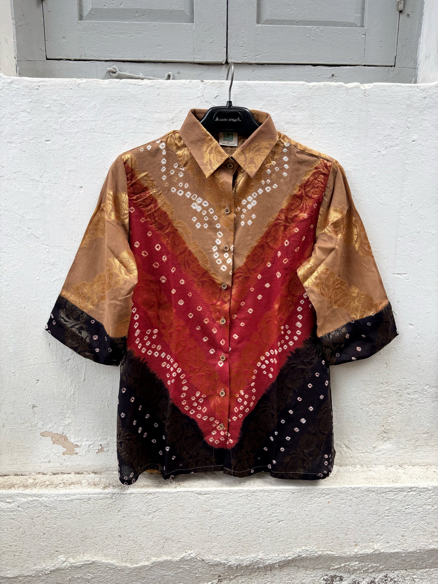 Handcrafted Bandhani festive cotton shirt in Earth Brown, Rustic Crimson and Classic Black with antique gold woven floral motifs, classic shirt collar, front button closure, relaxed fit and three-quarter sleeves.
