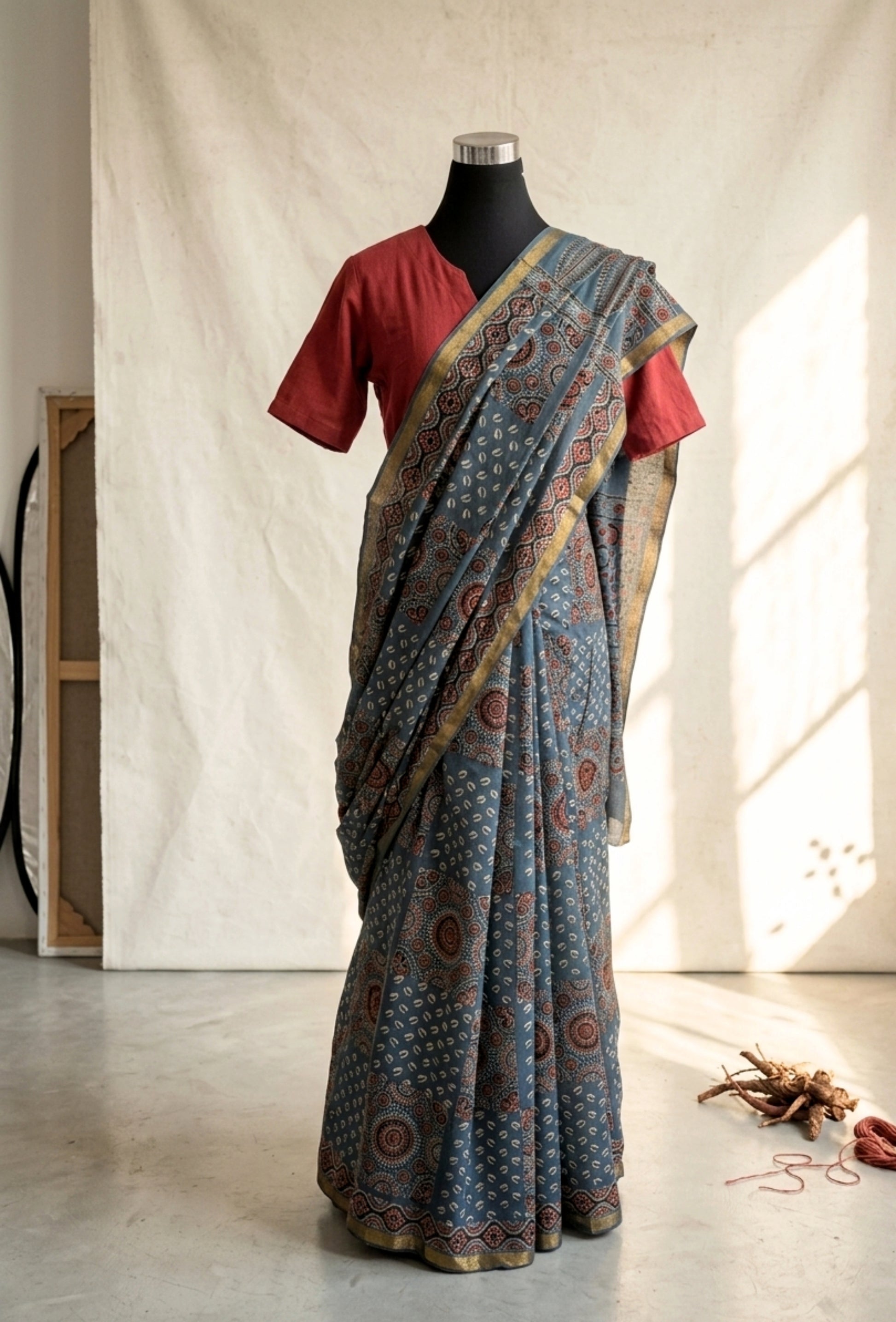 Indigo Ajrakh hand block printed cotton saree featuring traditional circular and geometric motifs with a thin border, paired with a madder dyed Ajrakh blouse piece.