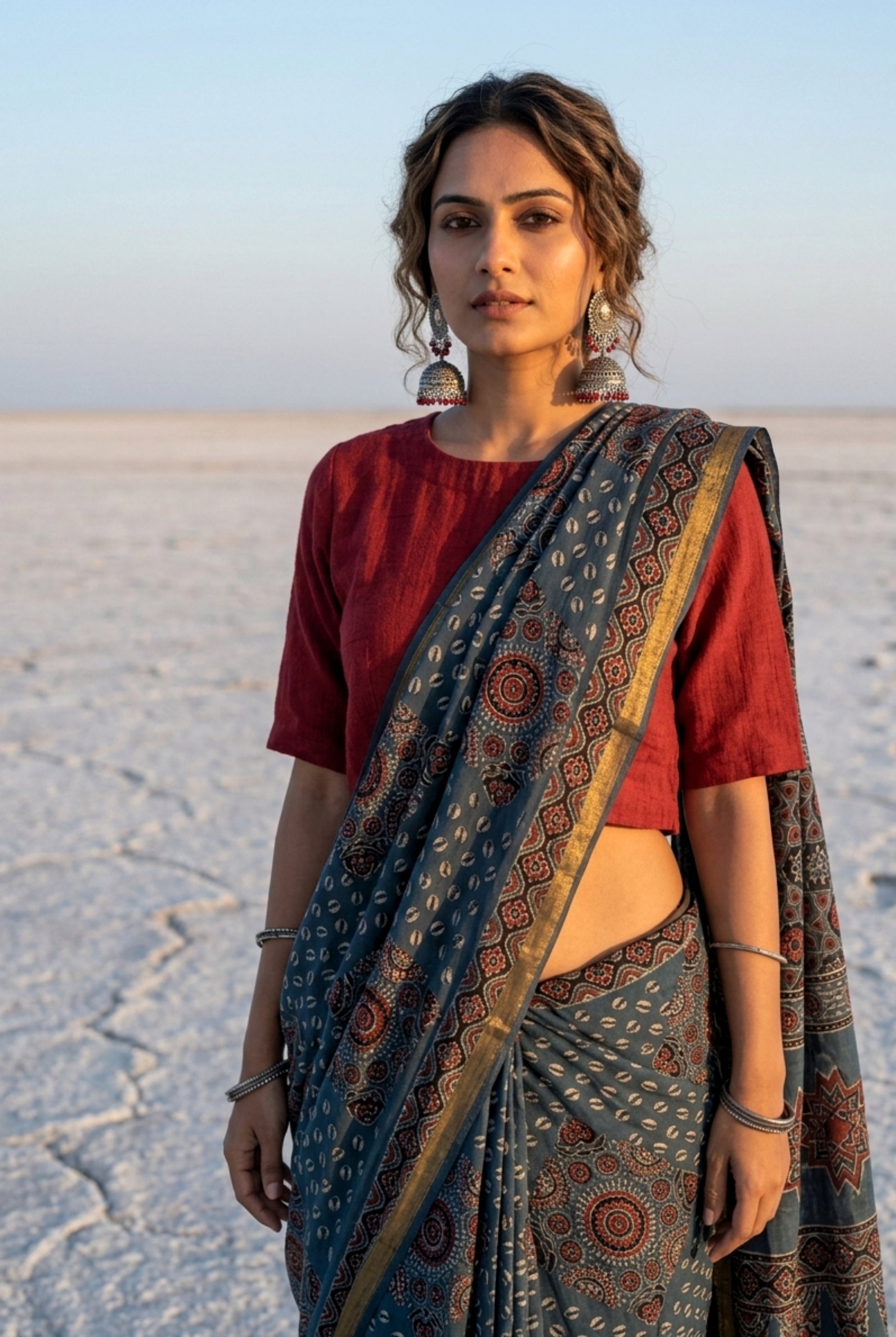 Indigo Ajrakh hand block printed cotton saree featuring traditional circular and geometric motifs with a thin border, paired with a madder dyed Ajrakh blouse piece.