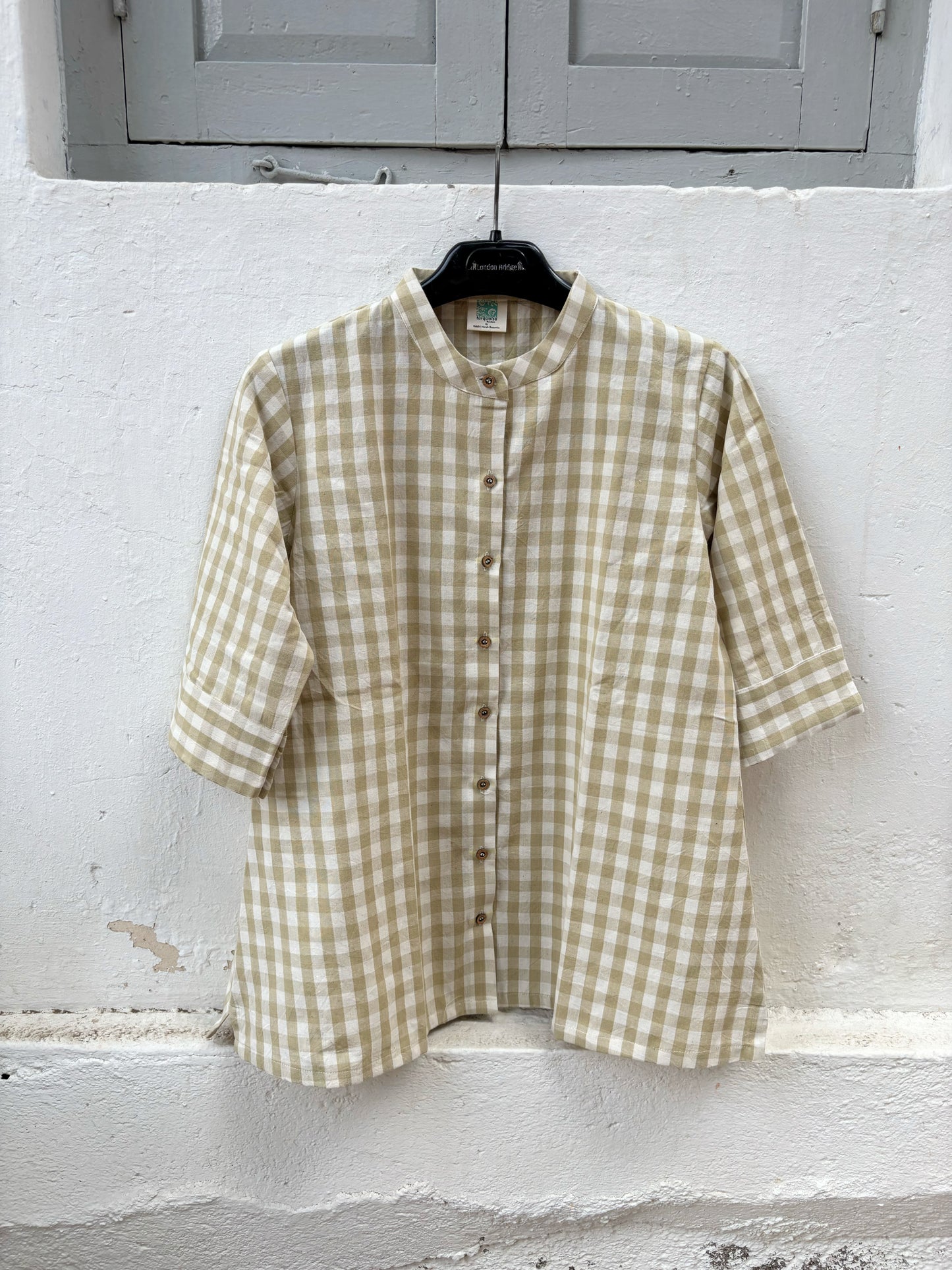 Olive Meadow hand spun handwoven cotton checks shirt in earthy olive and natural ivory gingham with a soft mandarin collar, wooden buttons and relaxed silhouette, paired with a raw undyed hand spun handwoven cotton skirt.