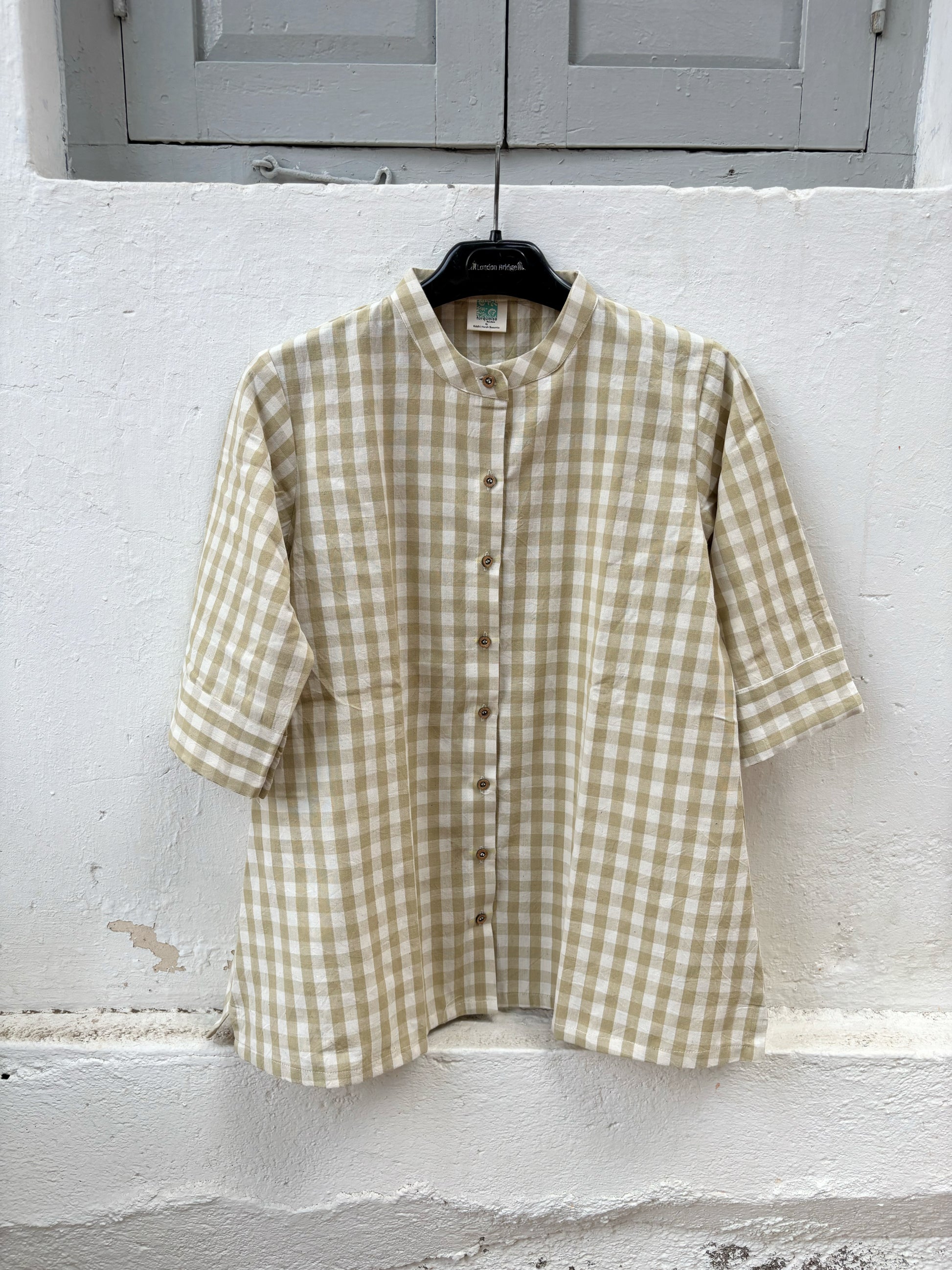 Olive Meadow hand spun handwoven cotton checks shirt in earthy olive and natural ivory gingham with a soft mandarin collar, wooden buttons and relaxed silhouette, paired with a raw undyed hand spun handwoven cotton skirt.
