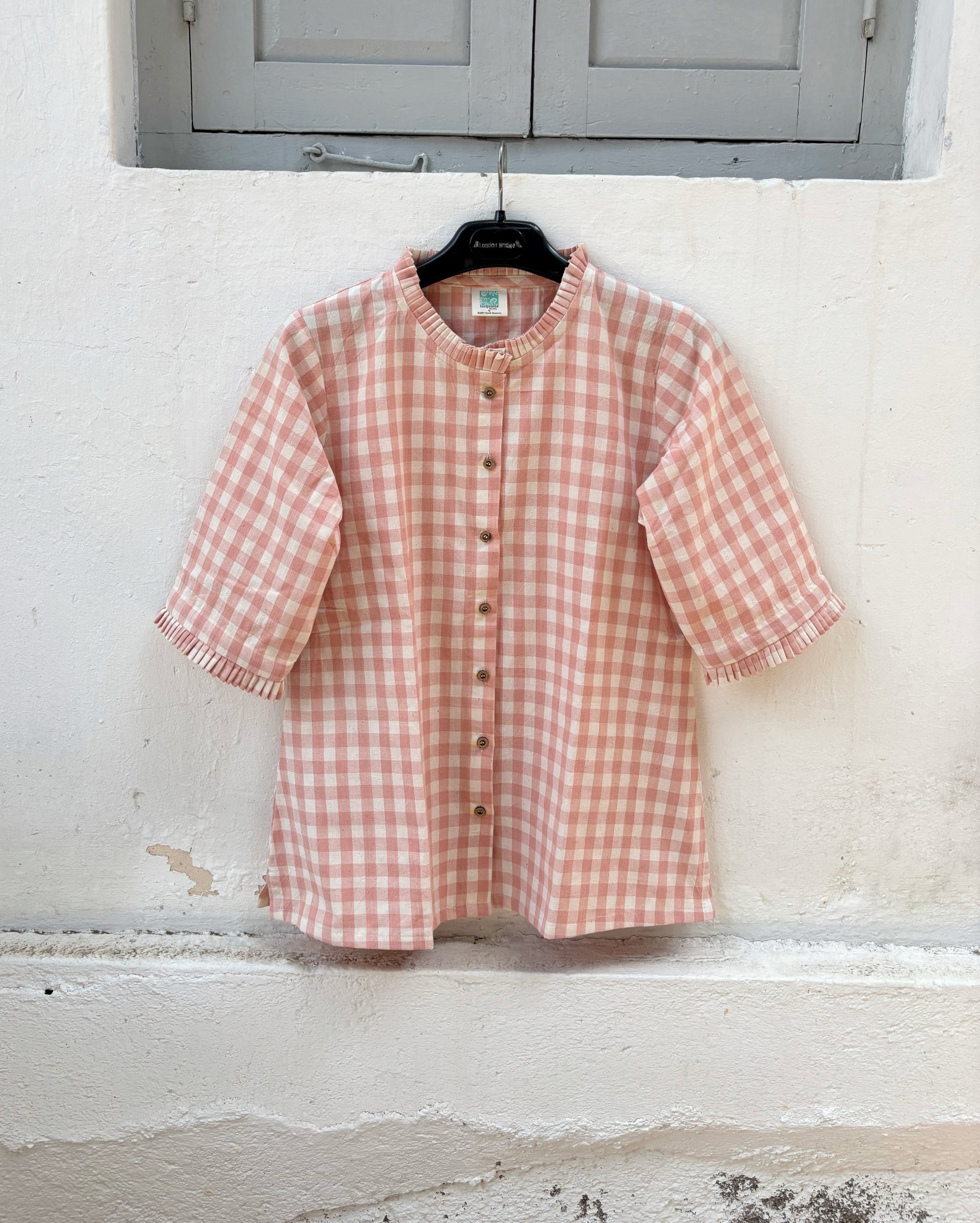 Peach Blush hand spun handwoven cotton checks shirt in pinkish peach and natural ivory with pleated neckline, pleated sleeve hems and wooden buttons.