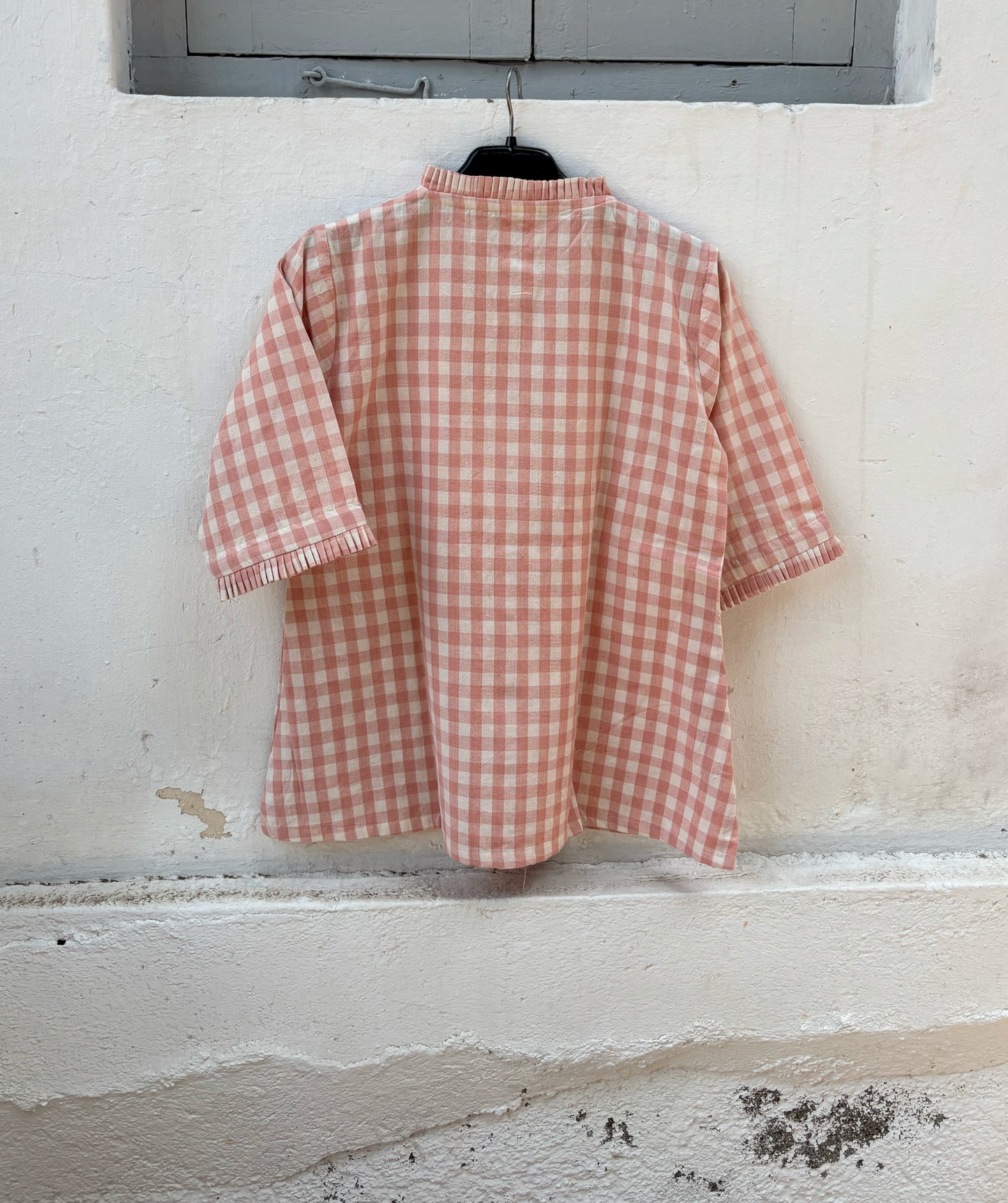 Peach Blush hand spun handwoven cotton checks shirt in pinkish peach and natural ivory with pleated neckline, pleated sleeve hems and wooden buttons.