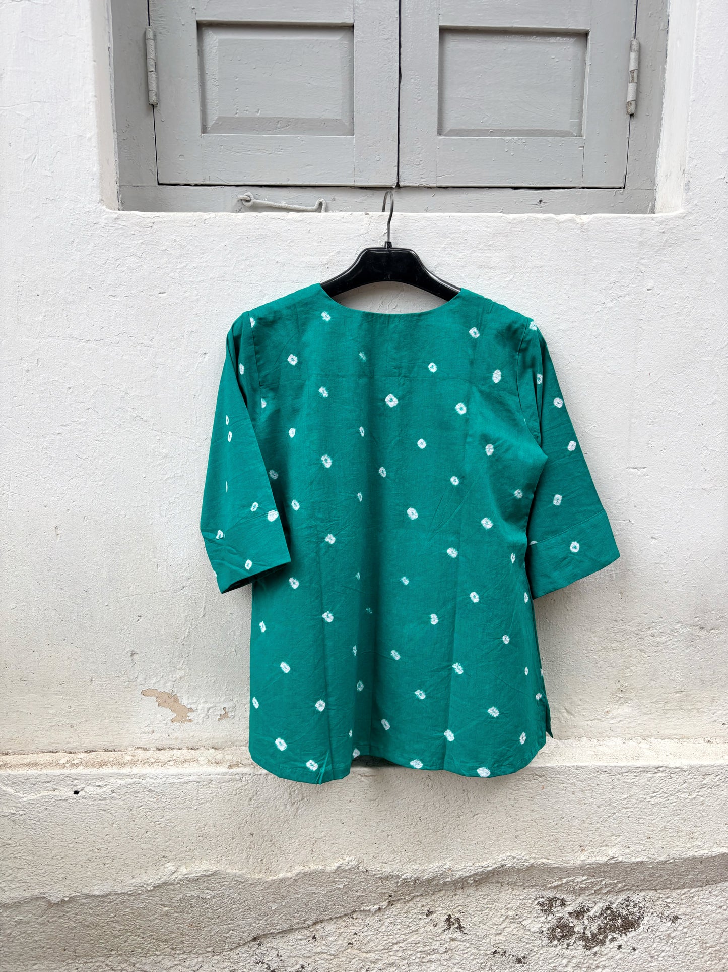 Handcrafted peacock blue cotton Bandhani top with white Bandhani motifs.