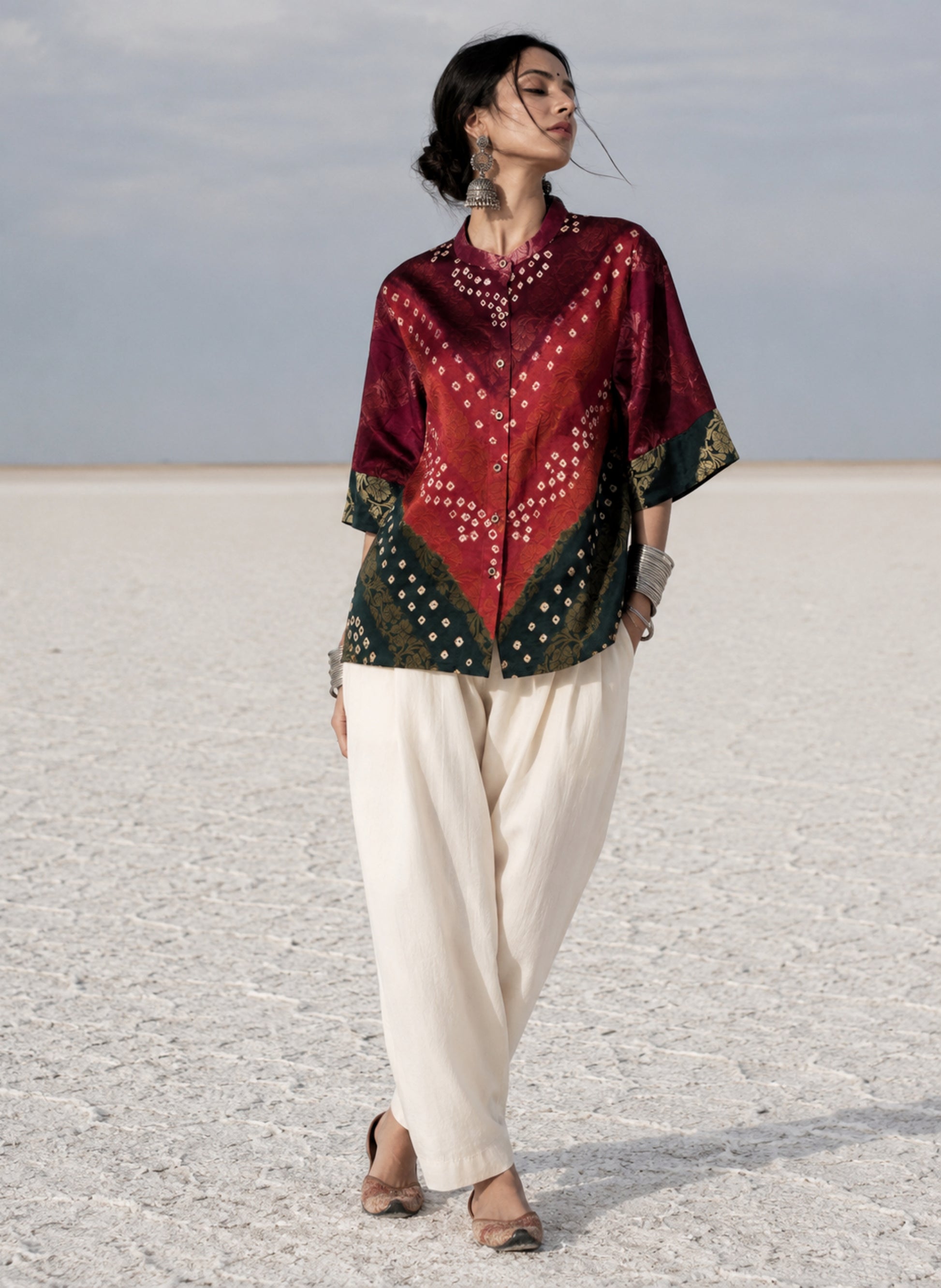 Handcrafted Bandhani festive cotton shirt in Wine Maroon, Rust Red and Deep Emerald Green with antique gold woven floral motifs, soft mandarin collar, short button placket, relaxed fit and three-quarter sleeves.
