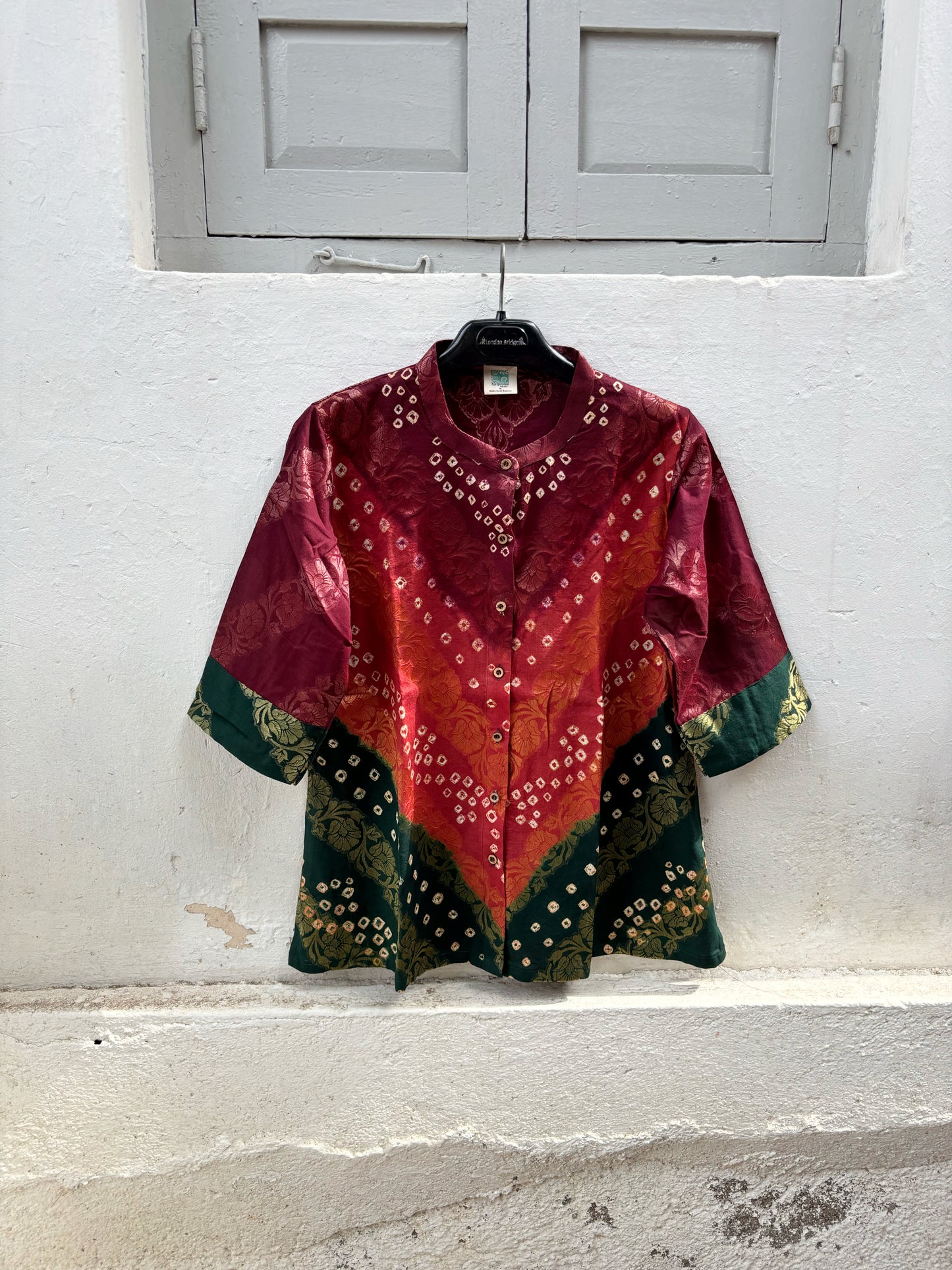 Handcrafted Bandhani festive cotton shirt in Wine Maroon, Rust Red and Deep Emerald Green with antique gold woven floral motifs, soft mandarin collar, short button placket, relaxed fit and three-quarter sleeves.
