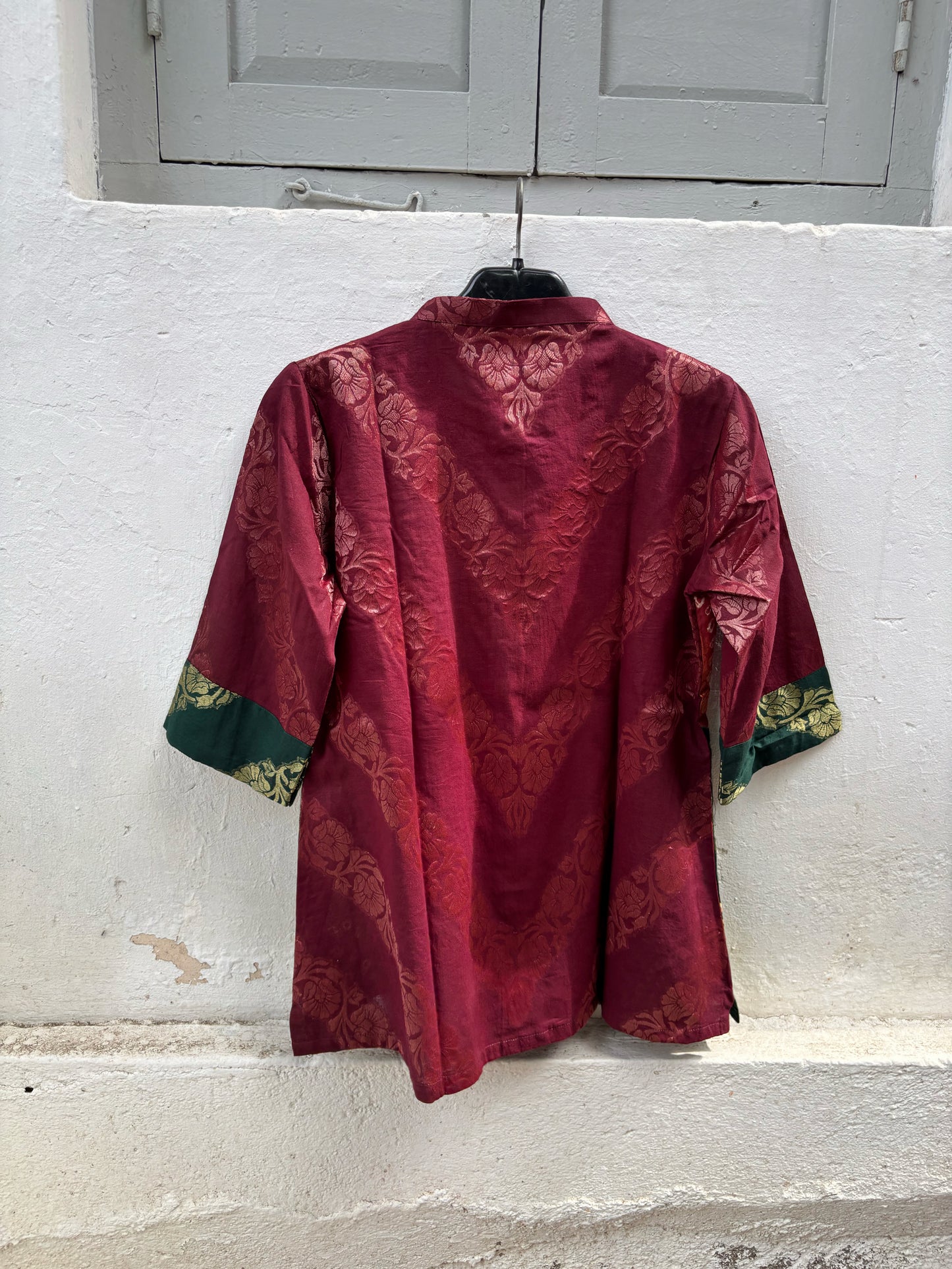 Handcrafted Bandhani festive cotton shirt in Wine Maroon, Rust Red and Deep Emerald Green with antique gold woven floral motifs, soft mandarin collar, short button placket, relaxed fit and three-quarter sleeves.
