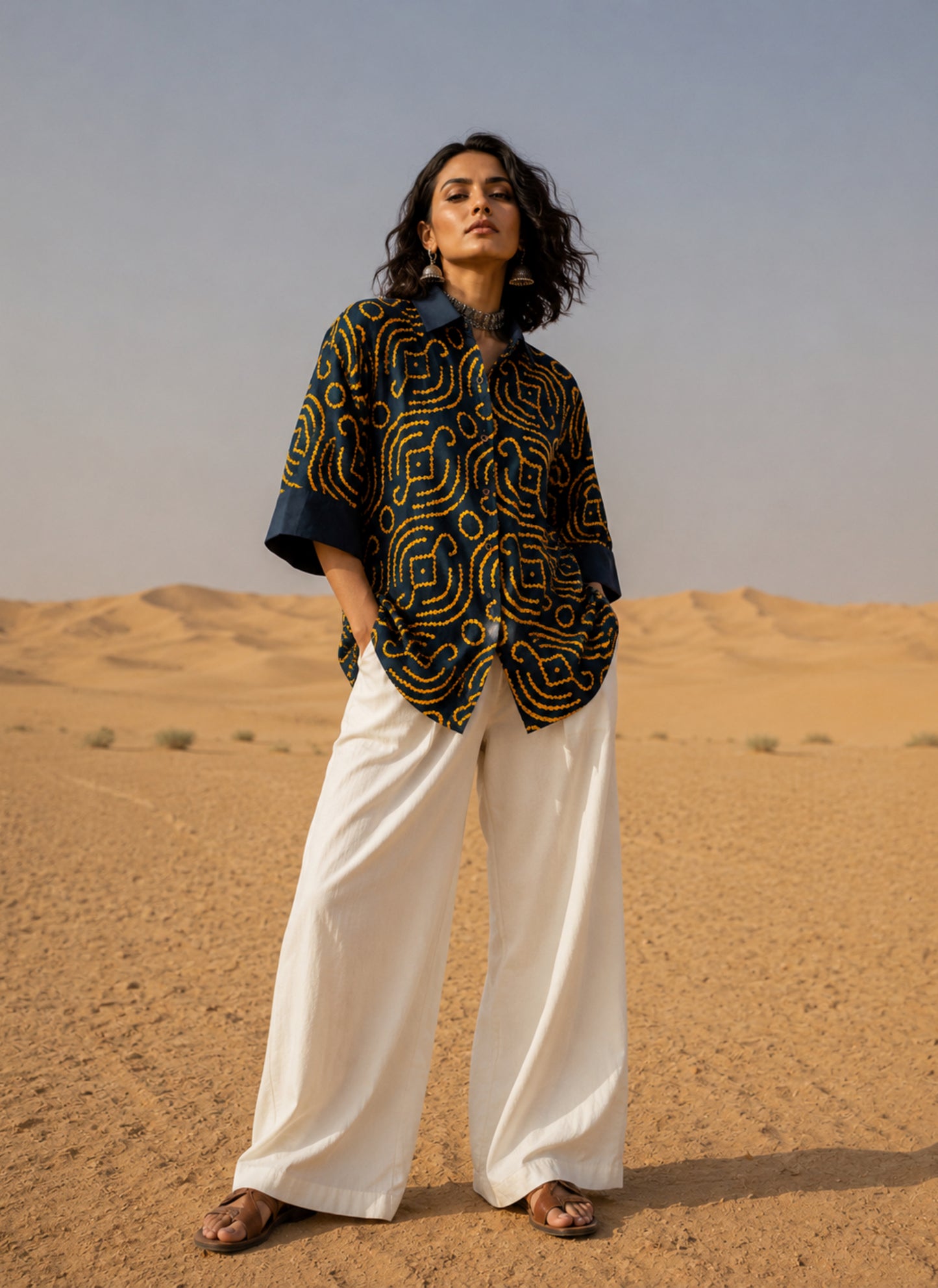 Jhankar Bandhani cotton shirt in midnight teal blue with saffron ochre motifs, classic shirt collar, folded sleeve cuffs, coconut shell buttons and relaxed fit.