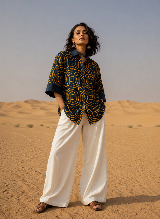 Jhankar Bandhani cotton shirt in midnight teal blue with saffron ochre motifs, classic shirt collar, folded sleeve cuffs, coconut shell buttons and relaxed fit.