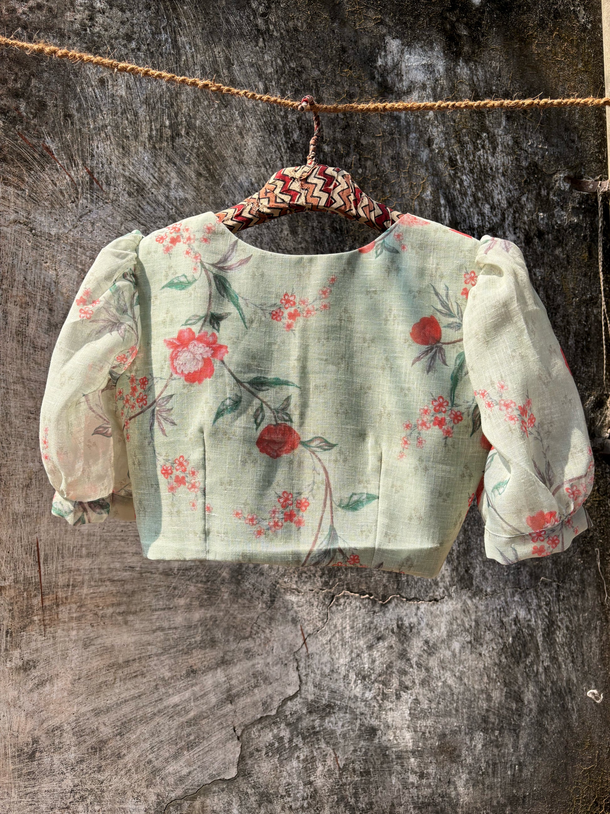 Slow-made sage green floral linen blouse with curved V-neck, front wooden buttons and subtle puff sleeves, fully lined and consciously crafted in India.