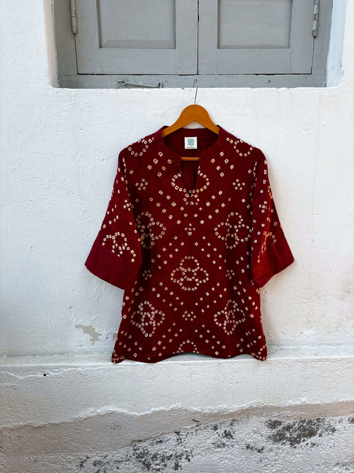 Sangria deep wine-red cotton satin top with ivory-beige hand tie-dyed Bandhani motifs and a soft mandarin collar with V-slit front.