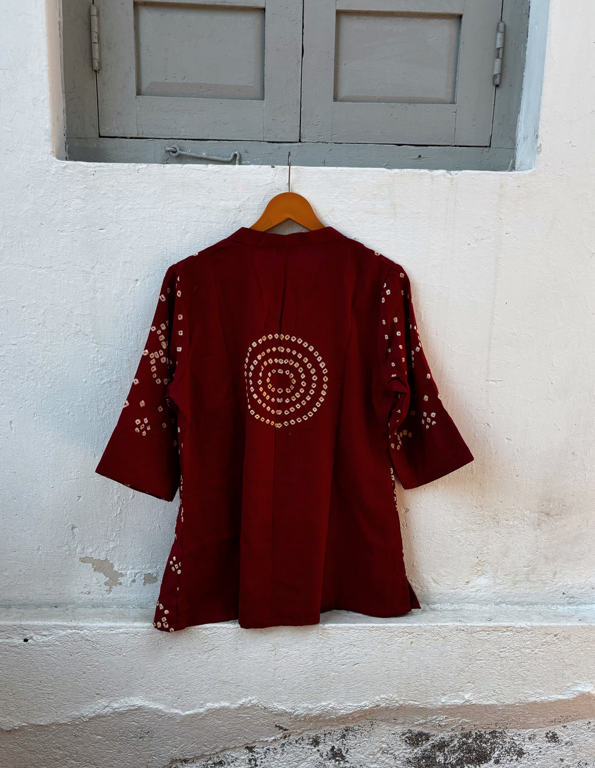Sangria deep wine-red cotton satin top with ivory-beige hand tie-dyed Bandhani motifs and a soft mandarin collar with V-slit front.