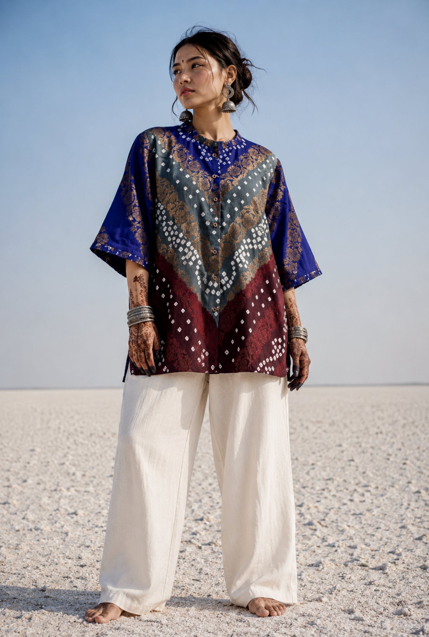 Handcrafted Bandhani festive cotton shirt in Royal Blue, Mist Grey and Wine Maroon with antique gold woven floral motifs, pleated round neckline, front button placket, relaxed fit and elbow sleeves.
