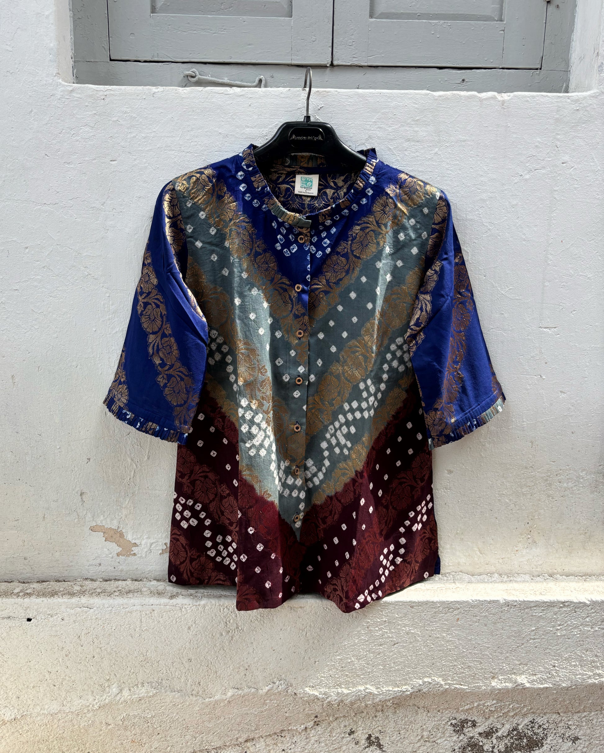 Handcrafted Bandhani festive cotton shirt in Royal Blue, Mist Grey and Wine Maroon with antique gold woven floral motifs, pleated round neckline, front button placket, relaxed fit and elbow length sleeves.
