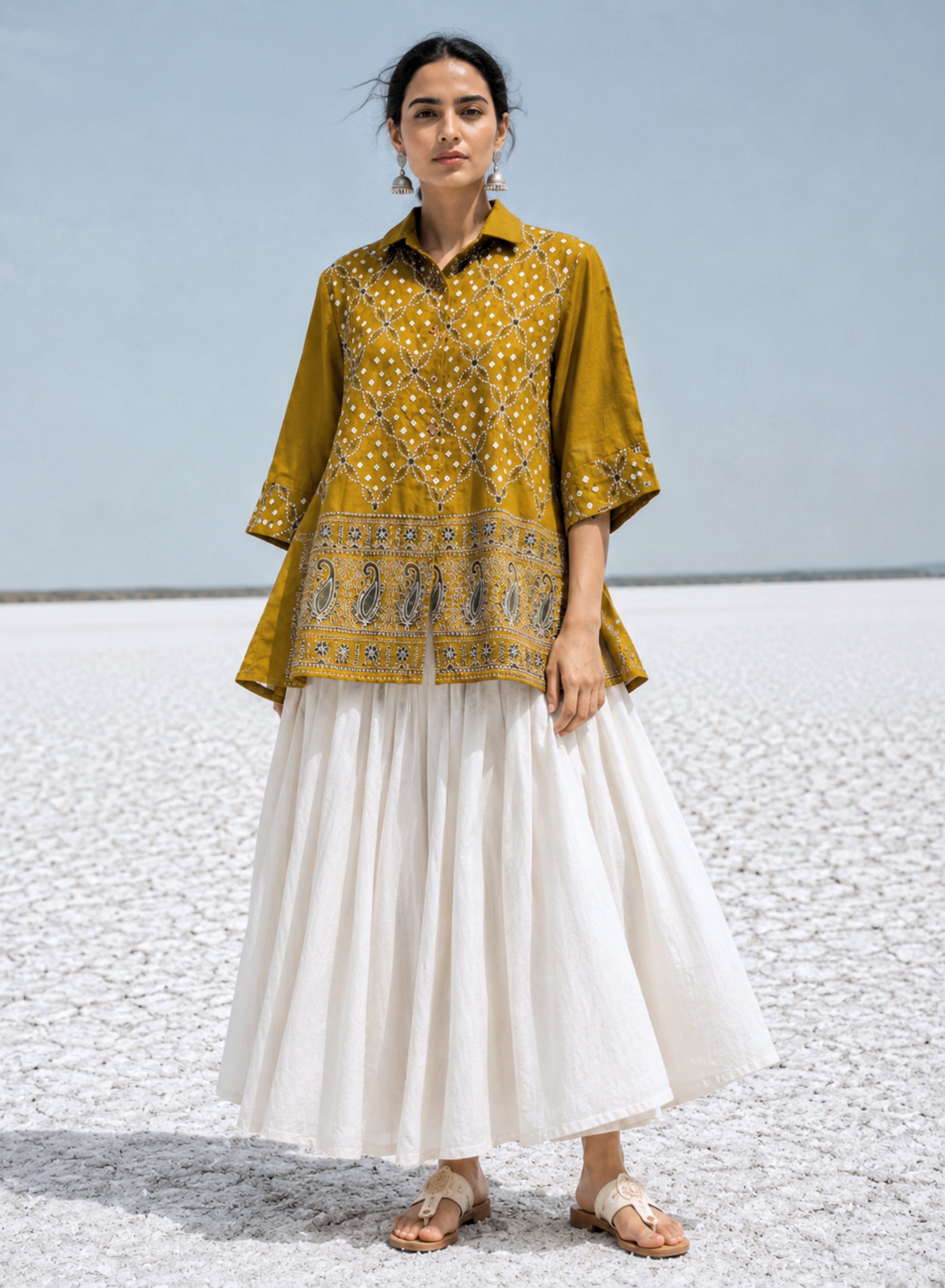 Warm mustard gold cotton satin Bandhani shirt with machine embroidered floral vine pattern, paisley border detailing, shirt collar, and relaxed fit.