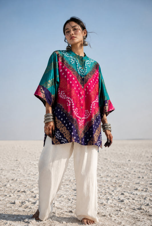 Handcrafted Bandhani festive cotton shirt in Peacock Blue, Fuchsia Pink and Royal Purple with antique gold woven floral motifs, round band neckline, short button placket, relaxed fit and three-quarter sleeves.