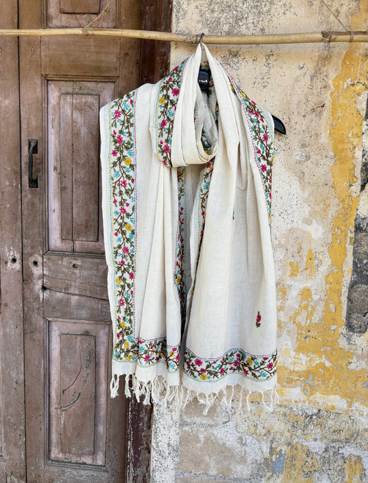 Handspun and handwoven cotton dupatta in warm ivory featuring delicate floral vine hand embroidery along the borders with small butti motifs and tassel edges.