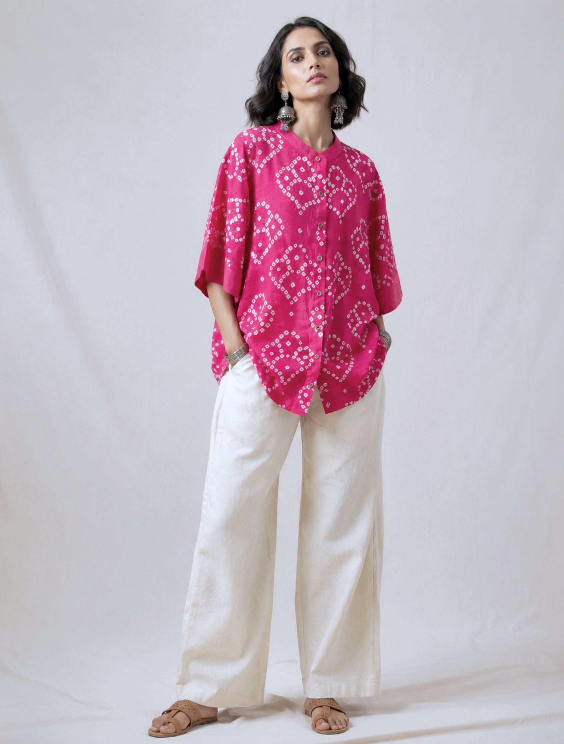 Hand tie-dyed Bandhani cotton satin shirt in Wild Rose Pink with white handcrafted Bandhani motifs, soft mandarin collar and relaxed fit.
